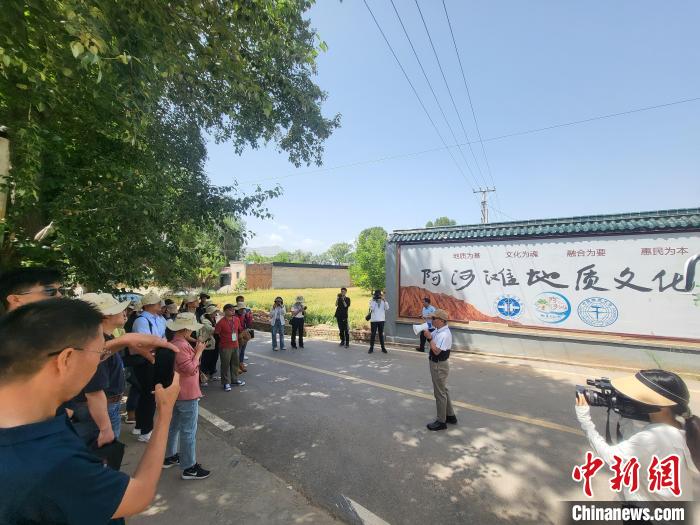 圖為中國地質(zhì)大學(xué)(北京)教授張緒教介紹村落情況?！『衍?攝