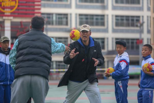 在高原上教孩子們打手球，“慢慢兒來，甭著急！”