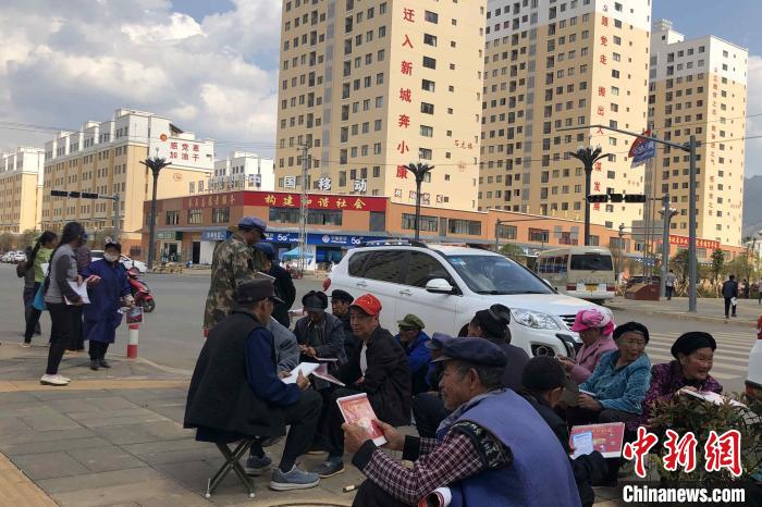 圖為會(huì)澤縣城易地扶貧搬遷安置點(diǎn)內(nèi)，老人們聚在廣場(chǎng)上聊天，身后是他們的新家。　繆超 攝