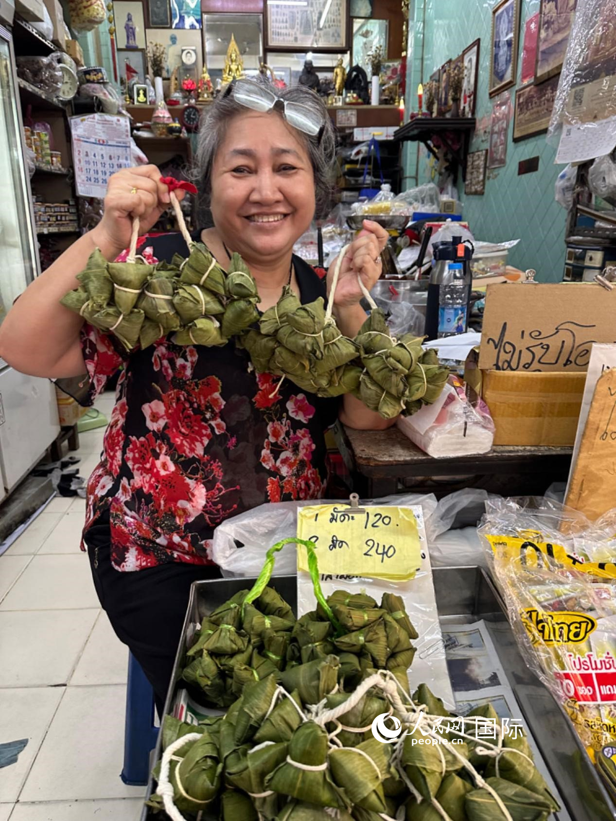 商家向顧客介紹“吉掌”（粽子的一種，一串一串，個(gè)頭較?。Ｈ嗣窬W(wǎng)記者 簡(jiǎn)承淵攝