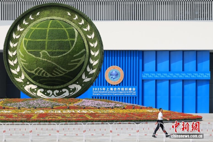 8月31日，天津，一名工作人員從2025年上海合作組織峰會主會場外的景觀花壇旁經(jīng)過。當(dāng)日，2025年上海合作組織峰會在天津舉行。<a target='_blank' href='/'><p  align=