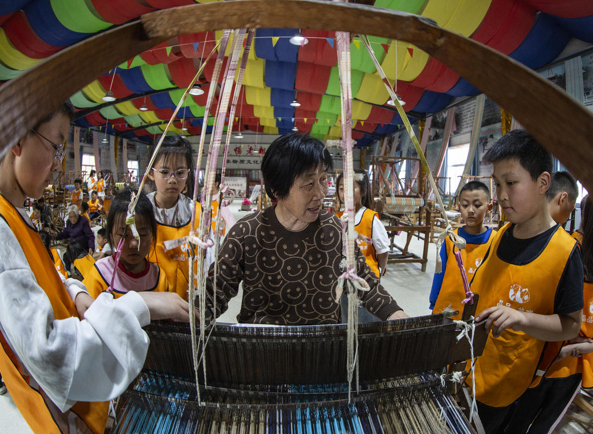 5月1日，在山西省永濟市開張鎮(zhèn)東開張村的惠暢土布文化園，土布制作技師教游客織布技藝。 來源：人民圖片網(wǎng)