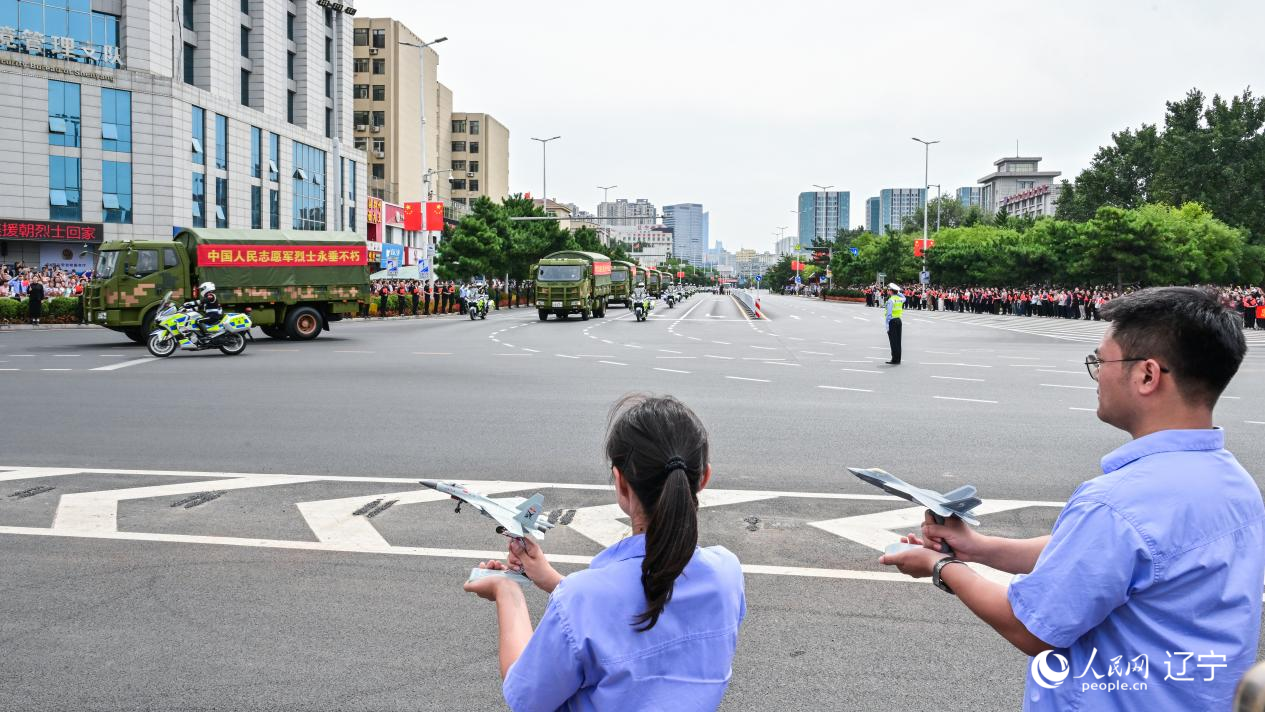 航空工業(yè)沈飛的青年技術(shù)人員拿著受閱戰(zhàn)機(jī)的模型迎接烈士遺骸。航空工業(yè)沈飛供圖