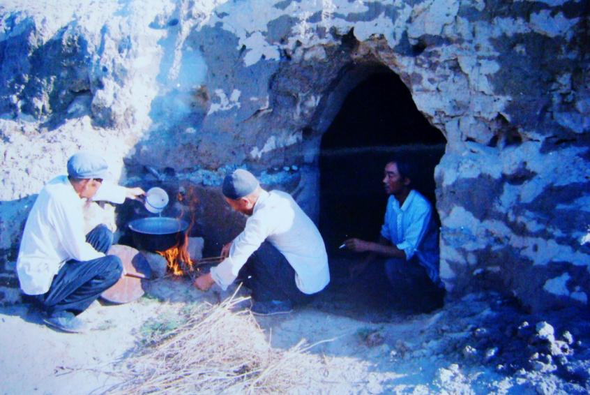 1983年，“六老漢”一代治沙人在“地窩子”生活做飯。新華社發(fā)（八步沙林場(chǎng)供圖）