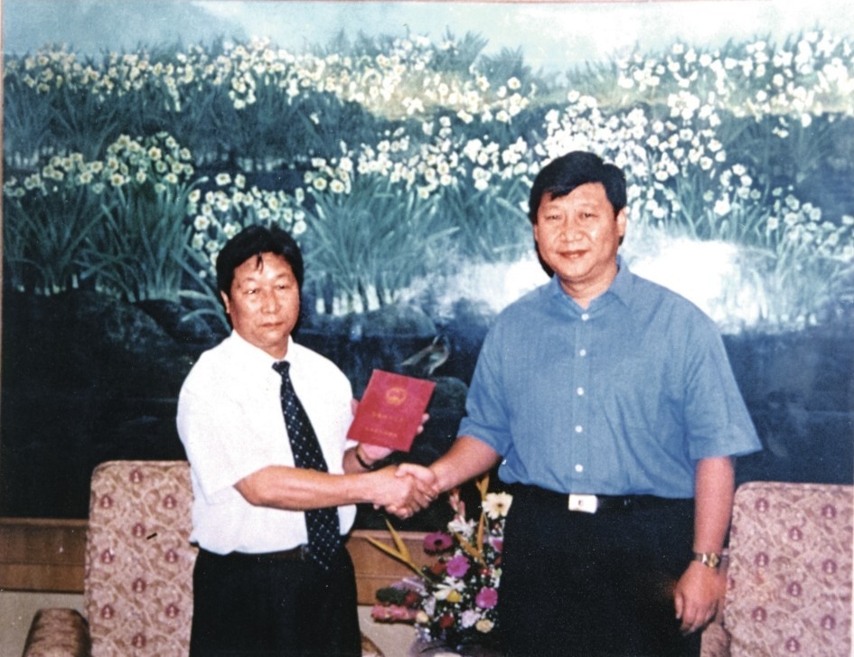 2000年7月，習近平為福建農(nóng)林大學教授林占熺頒發(fā)福建省政府“一等功”榮譽證書。圖源：《習近平在福建》（下）
