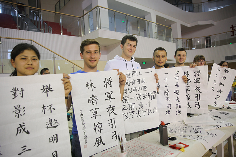 2017年6月5日，來自青島大學(xué)和中國石油大學(xué)（華東）的外國留學(xué)生在展示剛剛現(xiàn)場完成的書法作品。