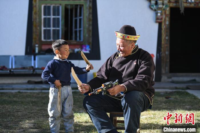 圖為米林縣扎西繞登鄉(xiāng)彩門村64歲的洛桑帶著孫子巴桑在院子的草地上玩耍?！『闻罾?攝