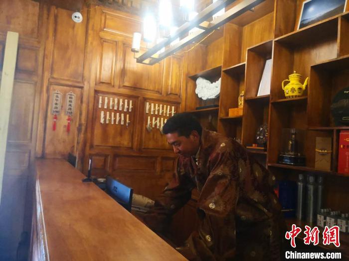 圖為桑杰才讓用電腦處理財(cái)務(wù)?！∈缝o靜 攝