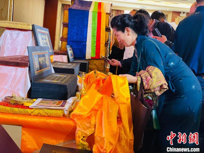圖為現(xiàn)場藏族民眾向黃金書寫的大藏經(jīng)《甘珠爾》敬獻哈達?！O睿 攝