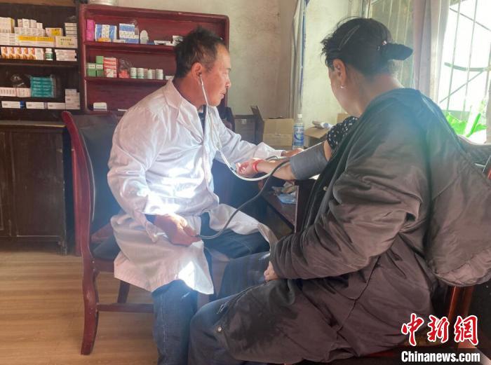 索木滾(左)為村民看病?！∪捞量h委宣傳部供圖