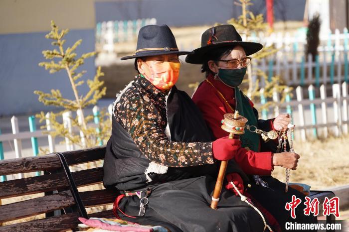 圖為敬老院老人在院內(nèi)曬太陽(yáng)轉(zhuǎn)經(jīng)桶。　馬銘言 攝