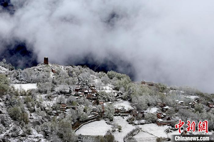 雪后的藏寨和碉樓構(gòu)成美麗的雪景?！〗党鯘衫?攝