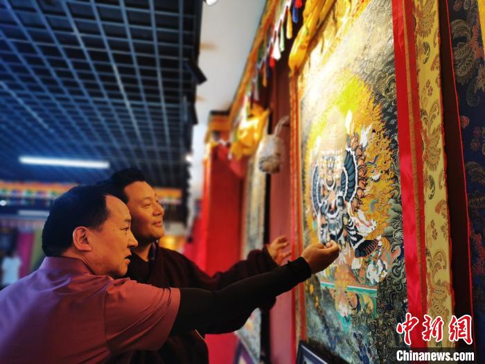 圖為久美尖措展示唐卡作品。　張?zhí)砀?攝