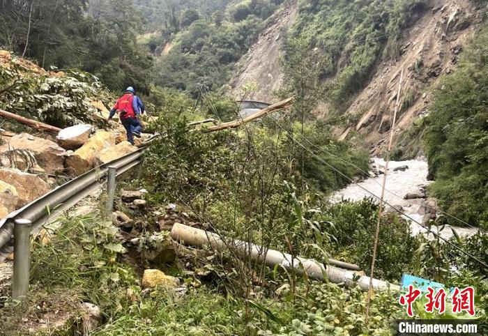 電力搶險人員快速通過危險路段，旁邊是受損的電力線路 四川電力供圖
