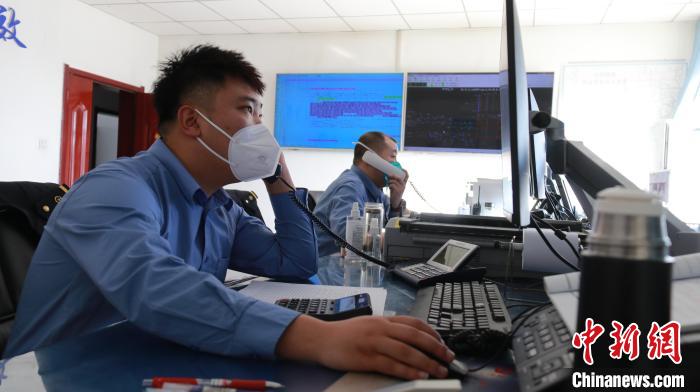 圖為貨運調(diào)度人員與外勤工作人員聯(lián)系掌握車輛裝載情況。　李生燕 攝