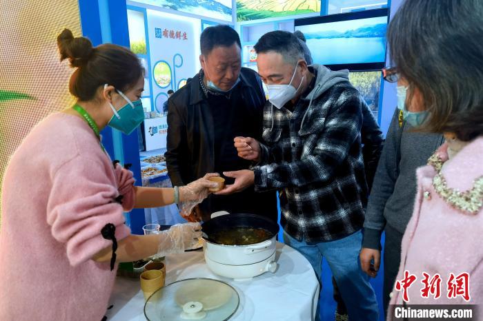 圖為杭州市民品嘗茶卡羊肉。　李雋 攝