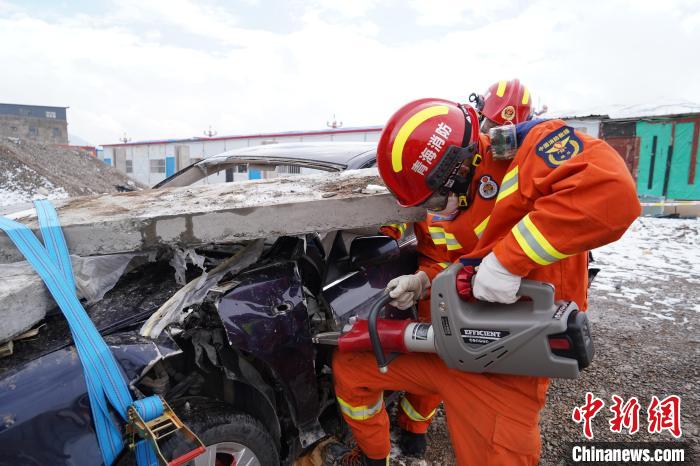 圖為地震實(shí)戰(zhàn)拉動現(xiàn)場，參演人員進(jìn)行車輛破拆?！∮駱湎拦﹫D