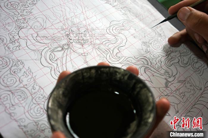 圖為唐卡繪畫班學(xué)員按《造像度量經(jīng)》繪制唐卡。　江飛波 攝