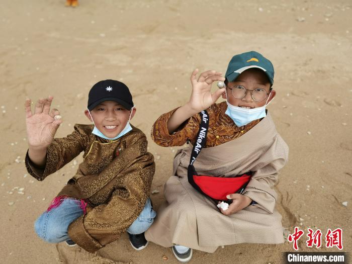 圖為西藏青少年在海邊拾貝殼。西藏航空 供圖