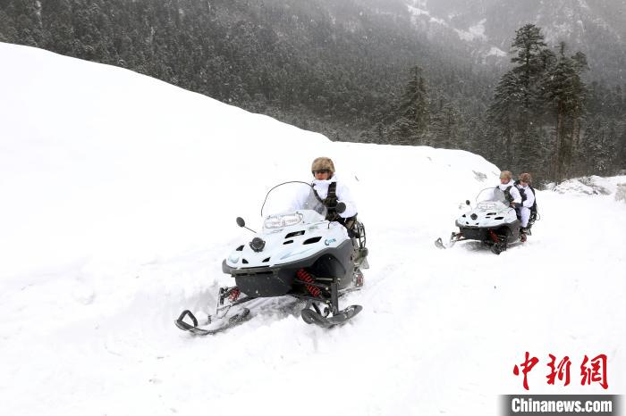 圖為雪地摩托車開路。　薛金博 攝