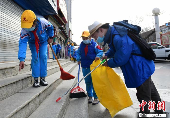 圖為拉薩市小學(xué)生打掃街道。　貢嘎來松 攝
