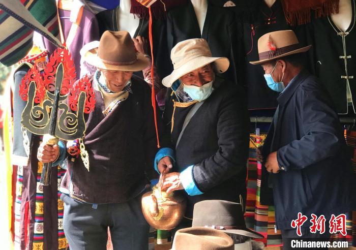 圖為三位藏族老人在集市上聊天交談?！∪轿木?攝