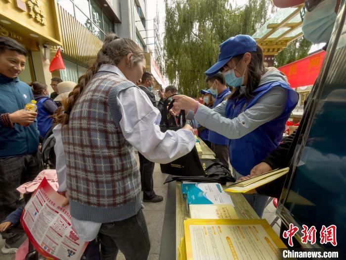 圖為志愿者為市民發(fā)放網(wǎng)絡(luò)安全宣傳手冊?！≈x牧 攝