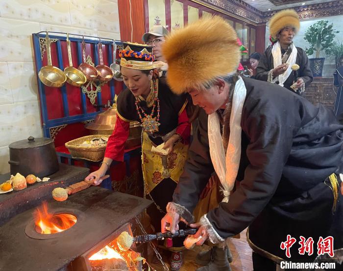圖為人們?cè)诨鹕峡竟?jié)日美食“結(jié)達(dá)”。　冉文娟 攝