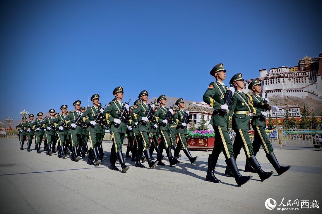 國旗護衛(wèi)隊隊員緊握鋼槍，踏著威武雄壯的步伐，走向國旗臺。人民網(wǎng) 次仁羅布攝