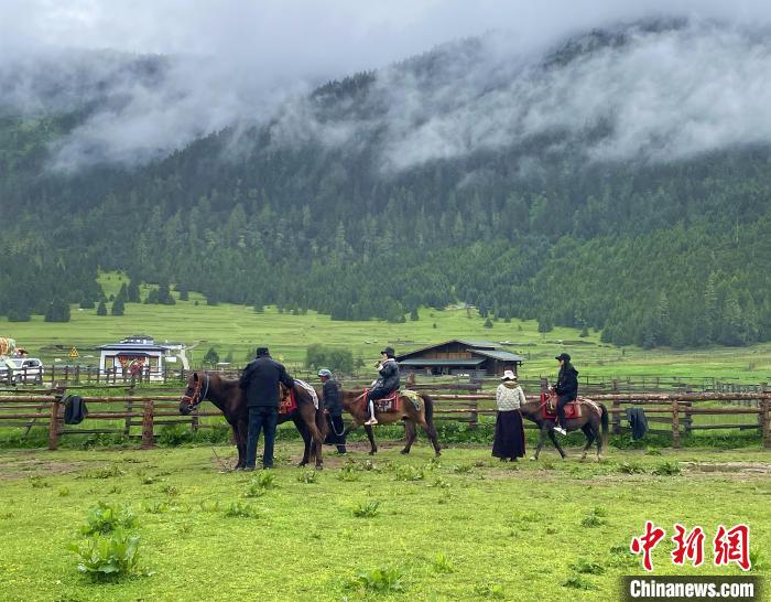 6月10日，游客在魯朗小鎮(zhèn)高山牧場(chǎng)景區(qū)體驗(yàn)騎馬。　冉文娟 攝
