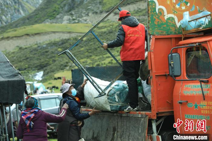 圖為工作人員幫助牧民們卸家具?！÷蹇?攝