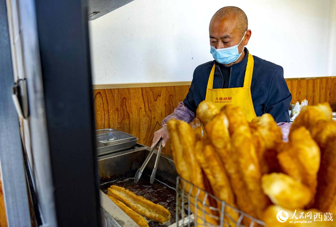 早餐店老板正在炸油條。人民網(wǎng) 次仁羅布攝