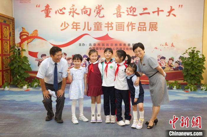 圖為與會(huì)嘉賓與入選畫作的“小作者”們在展覽上合影?！≈袊貙W(xué)研究中心供圖