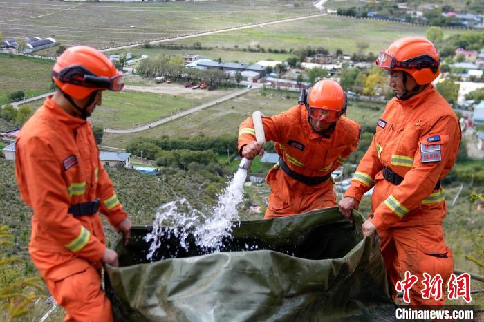 技能大練兵過程中，消防員在陡坡上向蓄水池注水?！±顕鵂c 攝