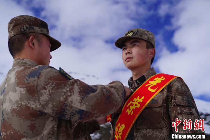 排長王朝偉(圖左)給退伍老兵佩戴大紅花?！∥鞑厣侥宪姺謪^(qū)某團(tuán)供圖