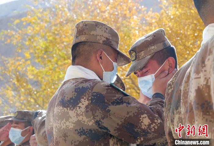 圖為什布奇邊防連退伍老兵與戰(zhàn)友相擁而泣，依依惜別。　徐昌成 攝