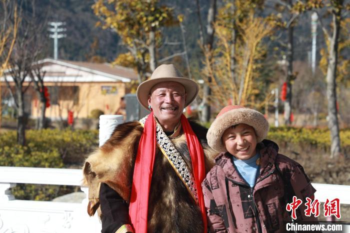 圖為林芝市巴宜區(qū)布久鄉(xiāng)仲果村村民桑杰與孫子一起參加藏歷新年活動。　張力 攝