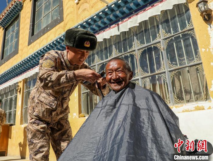 圖為阿里軍分區(qū)某邊防團(tuán)官兵為駐地群眾理發(fā)迎藏歷新年?！〉┰鰝愔?攝