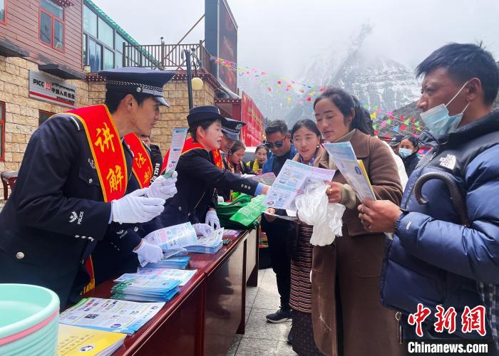圖為山南玉麥邊境派出所民警為轄區(qū)群眾發(fā)放法律知識宣傳單?！＄婗?　攝