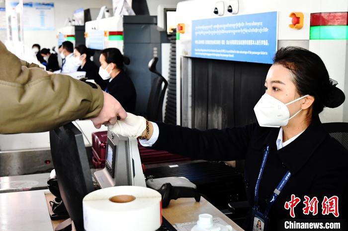 圖為機(jī)場工作人員為旅客辦理行李托運(yùn)?！≈芎?攝