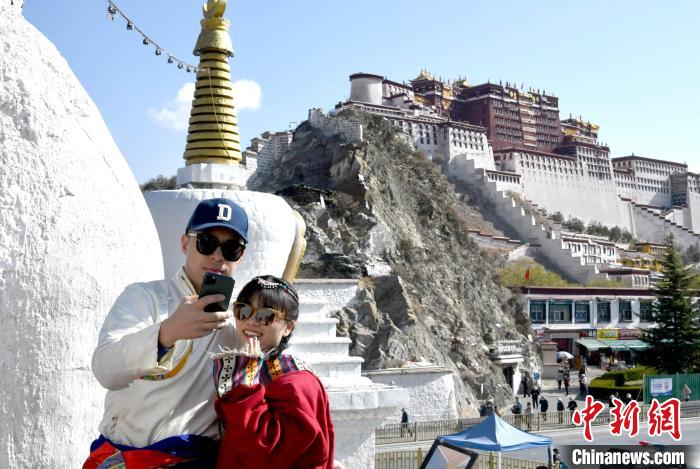 4月17日，游客身著藏式元素服裝在拉薩布達拉宮觀景臺拍照留念?！±盍?攝