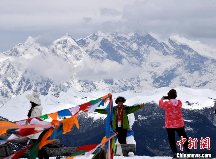 圖為5月14日，西藏林芝色季拉山觀景臺，游客與南迦巴瓦峰合影。　李林 攝