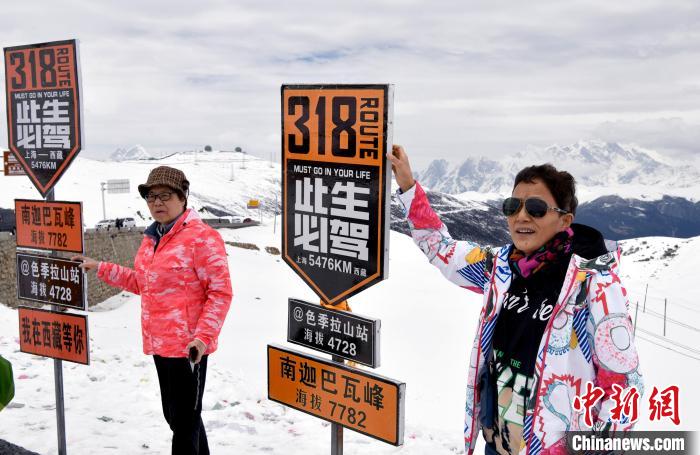 圖為5月14日，西藏林芝色季拉山觀景臺，游客與南迦巴瓦峰合影?！±盍?攝