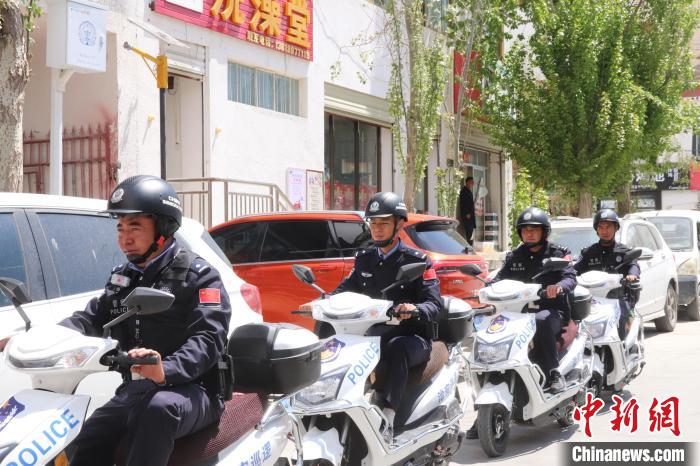 民警騎著電瓶車在轄區(qū)巡邏走訪。　黃創(chuàng)偉 攝