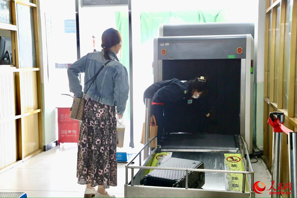 車站工作人員幫旅客提取行李。人民網(wǎng)記者 次仁羅布攝