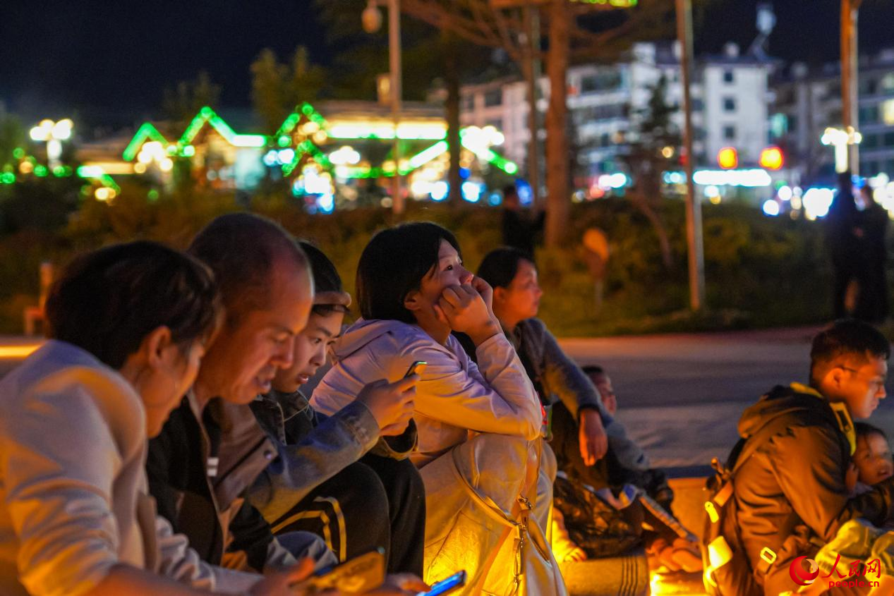 市民坐在西藏林芝市民族團結(jié)廣場臺階上欣賞音樂噴泉。人民網(wǎng)記者 趙晨攝