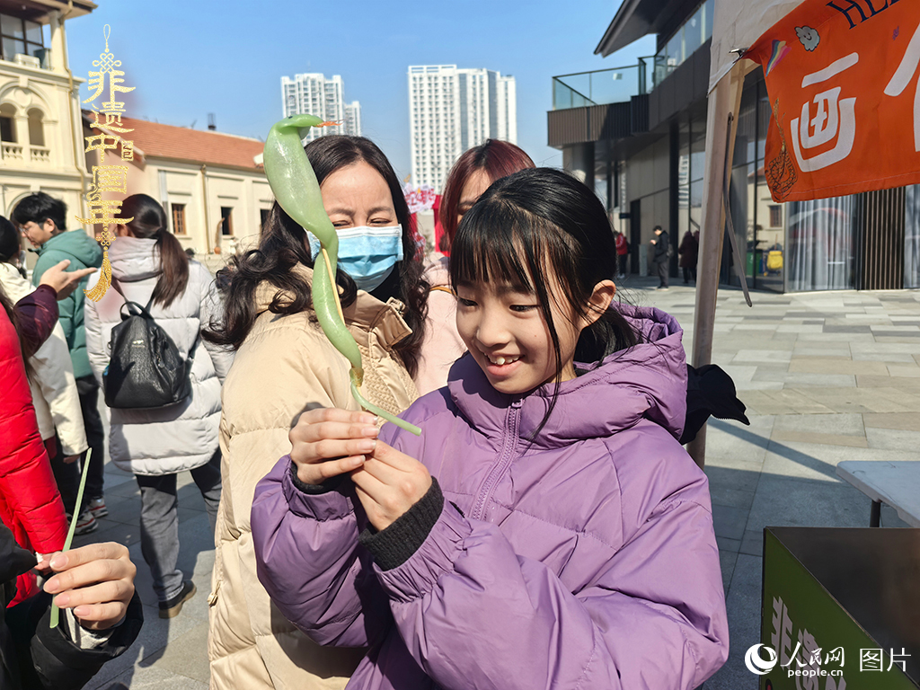 2025年1月29日，湖北武漢的新春廟會上，小朋友拿著吹制好的糖人，十分開心。人民網(wǎng)記者 張沛攝