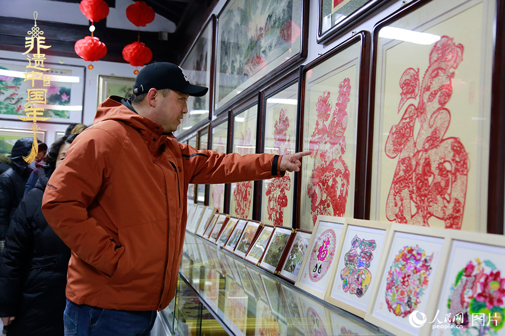 2025年1月23日，游客在天津楊柳青古鎮(zhèn)欣賞傳統(tǒng)剪紙作品，感受指尖上的古老藝術(shù)。人民網(wǎng)記者 崔新耀攝